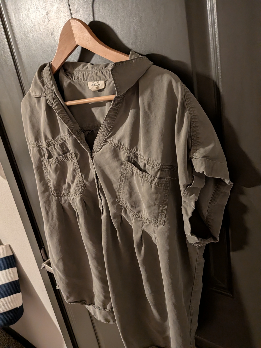 olive green button-up shirt featuring rolled sleeves and dual front pockets.